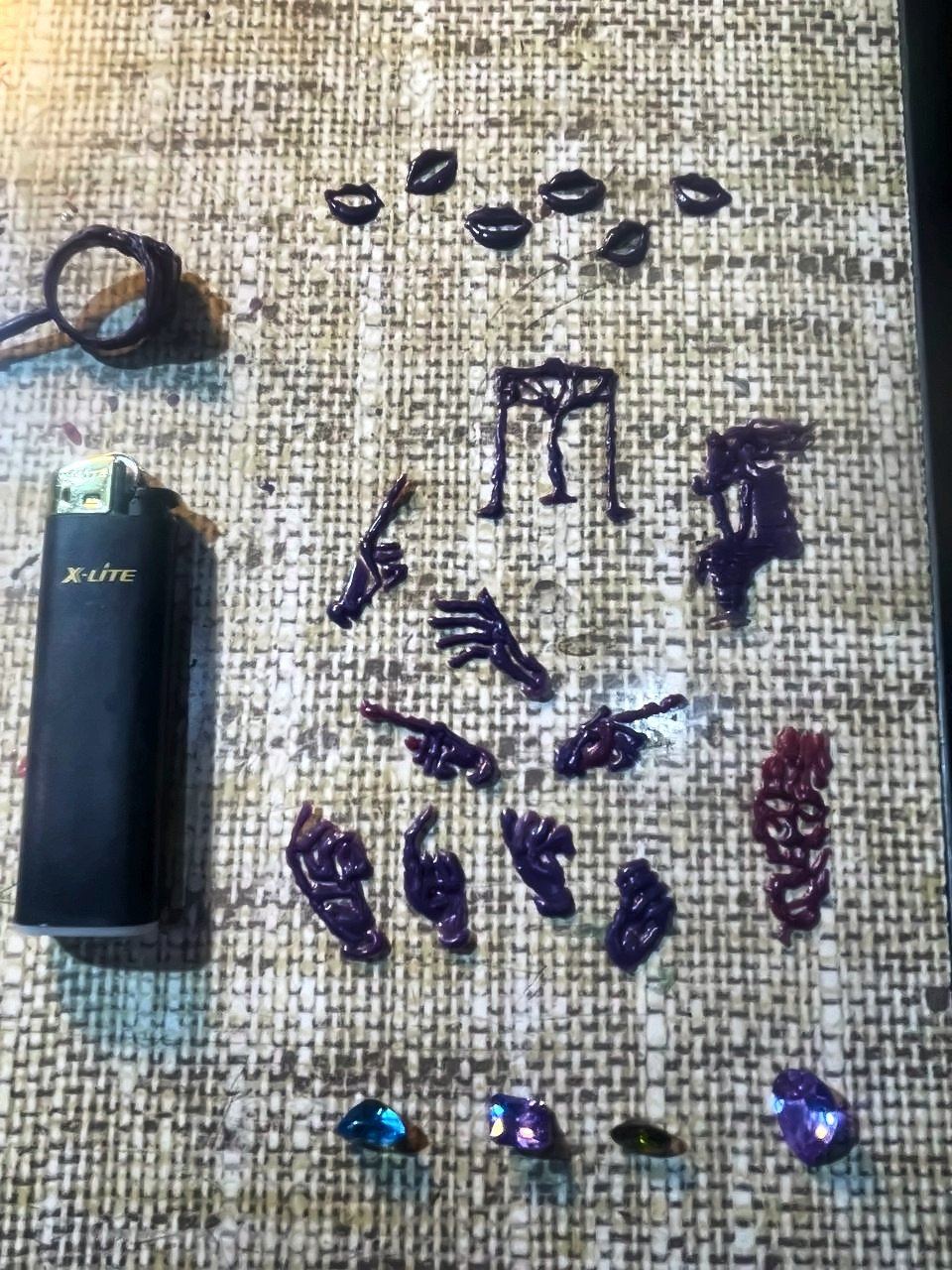 Modelos de cera con forma de manos y labios sobre arpillera.