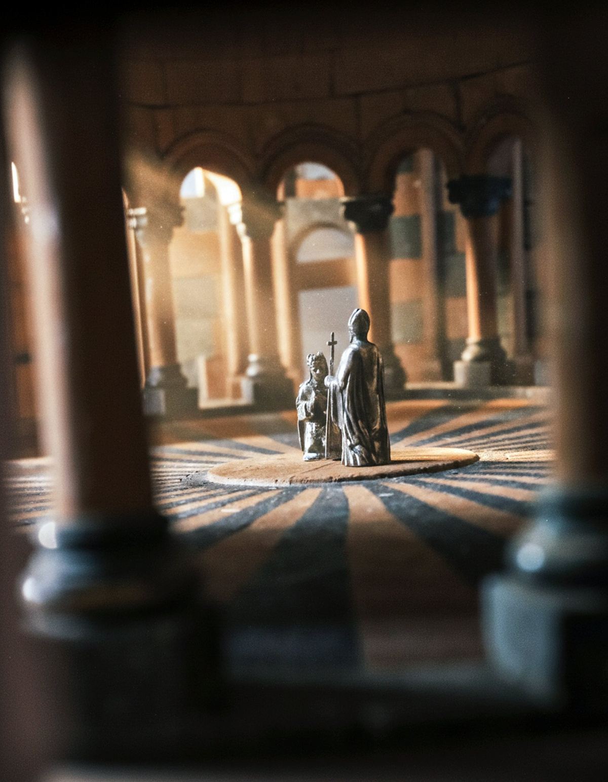 Interior de la maqueta de Zvartnots: columnas y figuras de santos bajo los arcos.